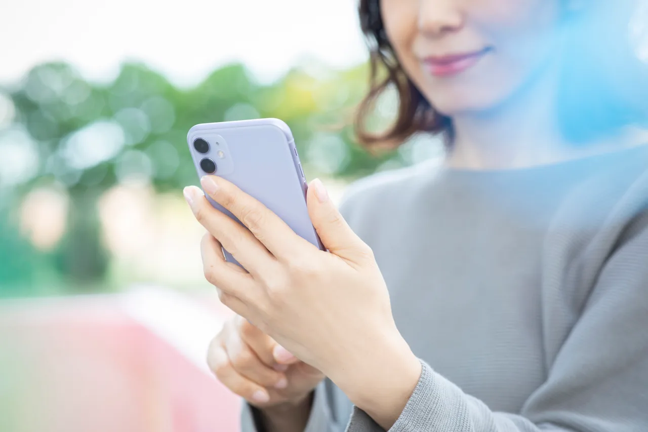 スマートフォンで近くの店舗を探す女性
